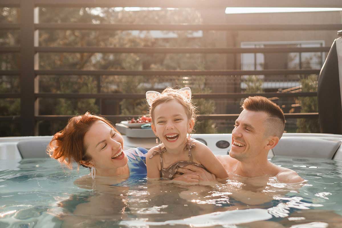 Family rests in the outdoor hot tub-Empire Pool & Patio Family rests in the outdoor hot tub-Empire Pool & Patio